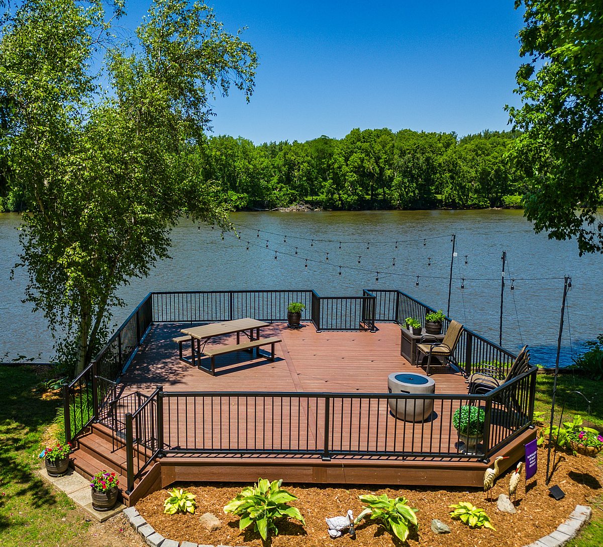 Framing a waterfront view, this 529-square-foot Brazilian Cherry deck pairs natural scenery with reliable engineering built to last a lifetime. Green Shield optimizes the layout for picnic tables and patio furniture.