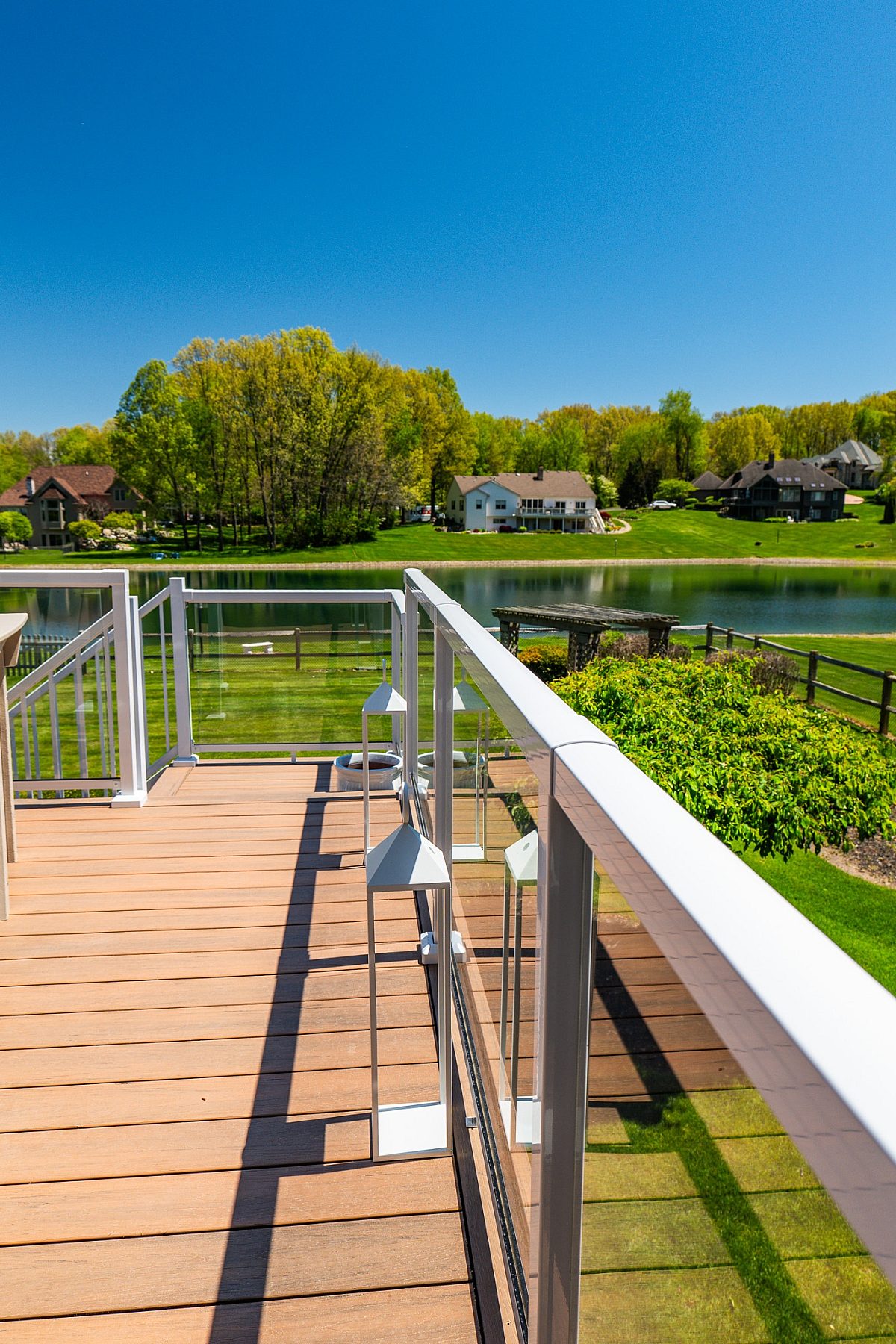 Waterfront Green Shield deck with White Framed Glass Aluminum Deck Railings.