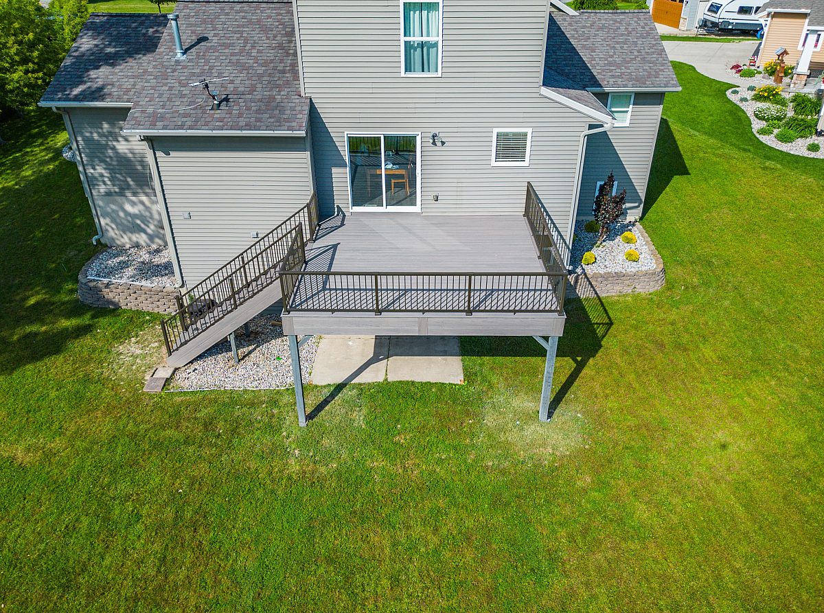 Framing an open 280-square-foot footprint, warm Hazelwood composite decking is bordered by bronze balusters for defined but unobstructed views. Green Shield pairs premier materials with reliable engineering, built to last.