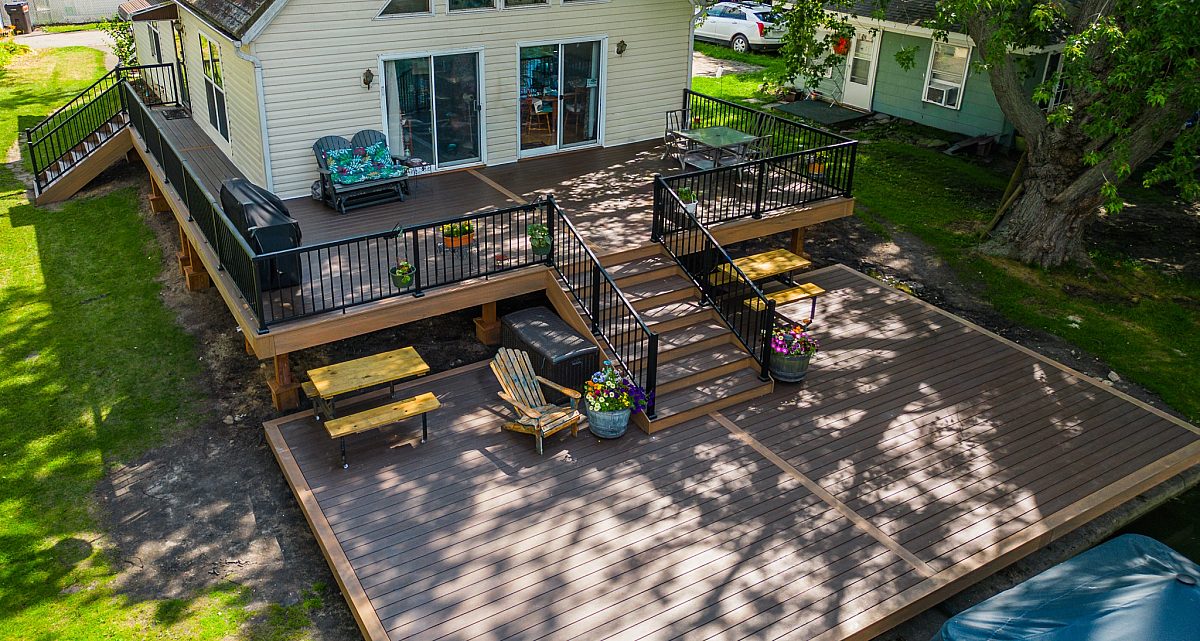 Rail Free Green Shield deck design on waterfront near lake with Tigerwood deck boards, trimmed out in lighter Tropical Walnut.